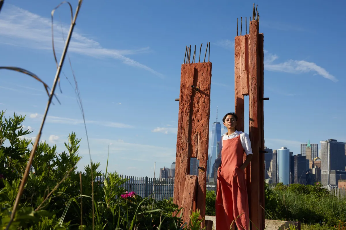 صورة لمريم تركي تقف أمام أحد أعمالها