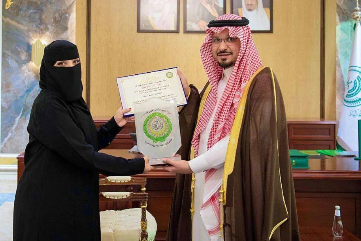 تظهر الصورة تكريم الأمير فيصل بن خالد بن سلطان لابتسام