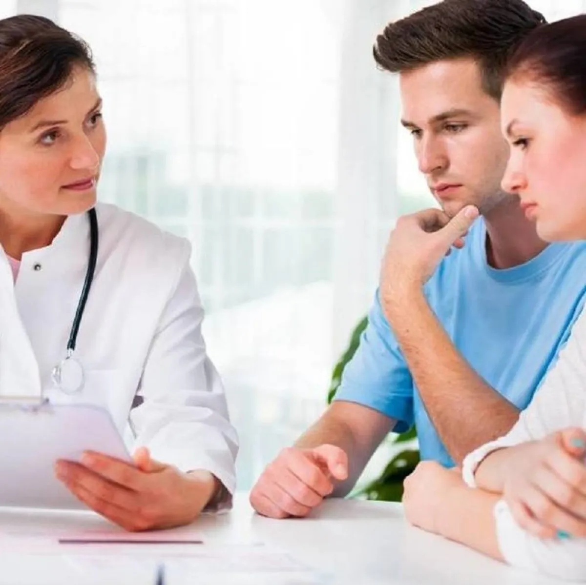 صورة لحامل وزوجها أمام الطبيبة