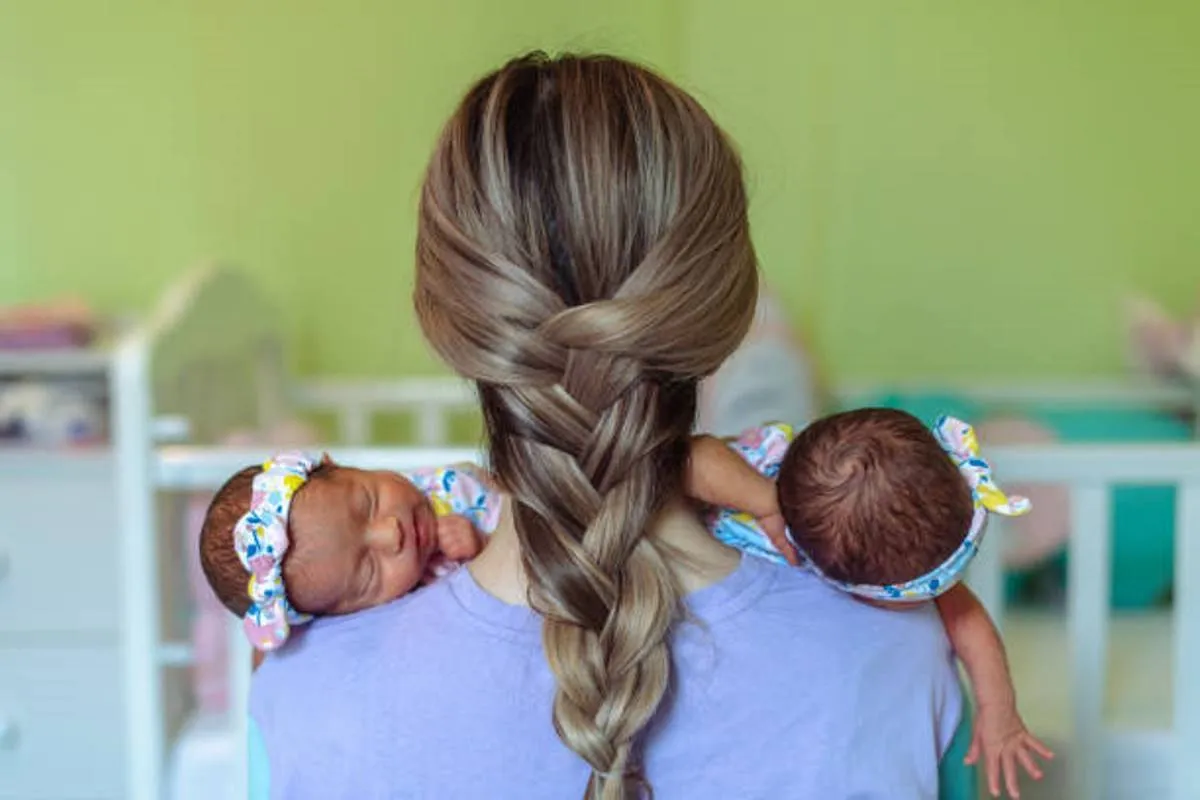 صورة لأم تعتني بتوأمها