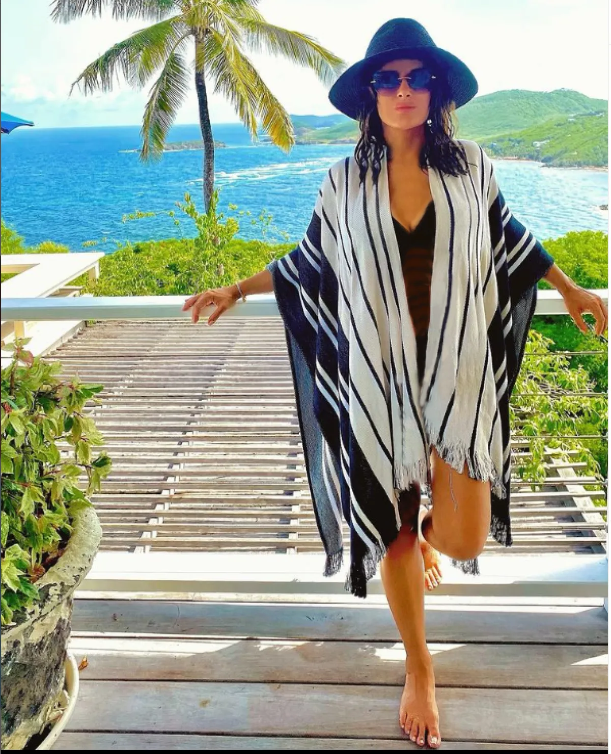 سلمى حايك ترتدي القفطان على شاطئ البحر مع قبعة