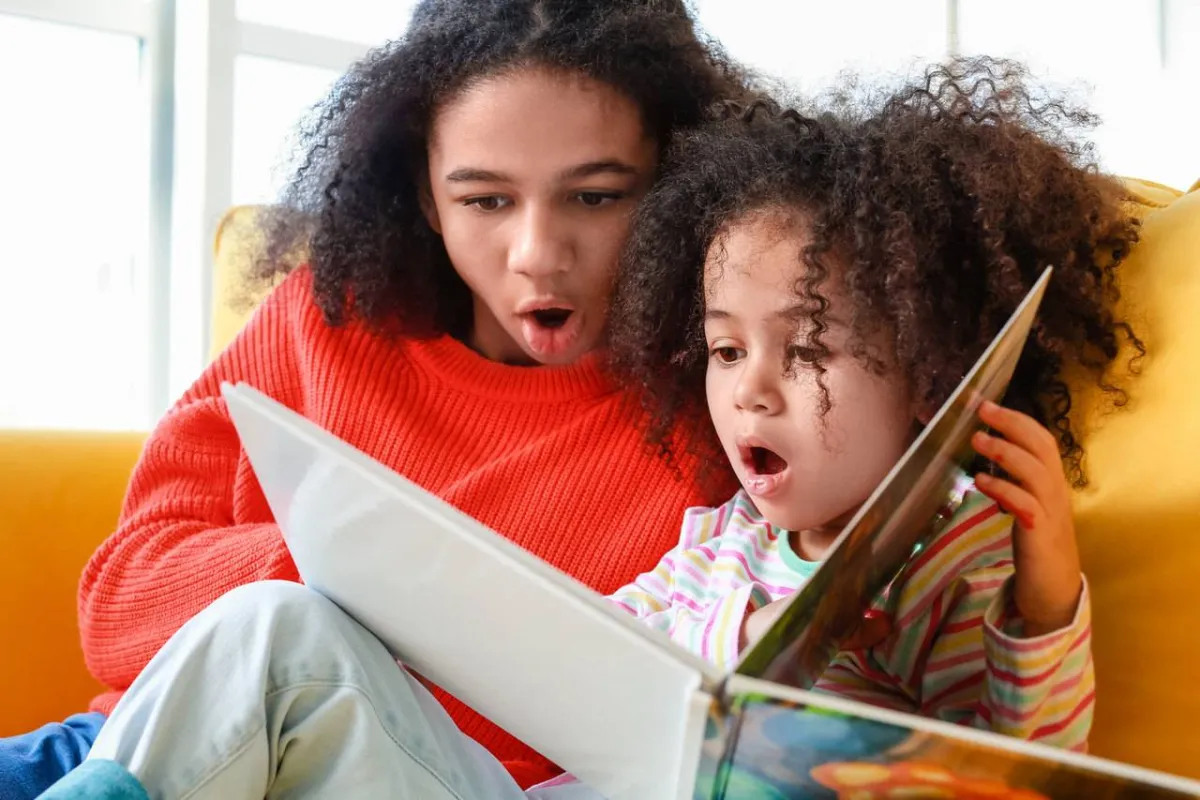 صورة لأم تعلم طفلتها القراءة