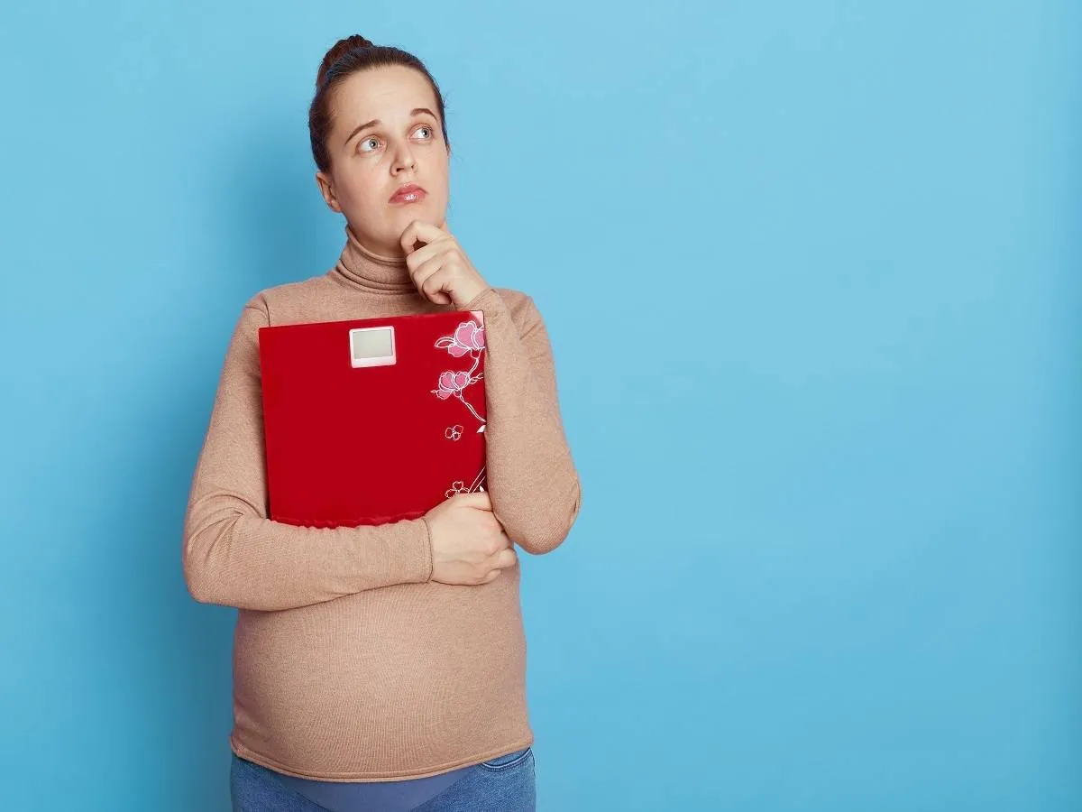 صورة لامرأة حامل تمسك الميزان