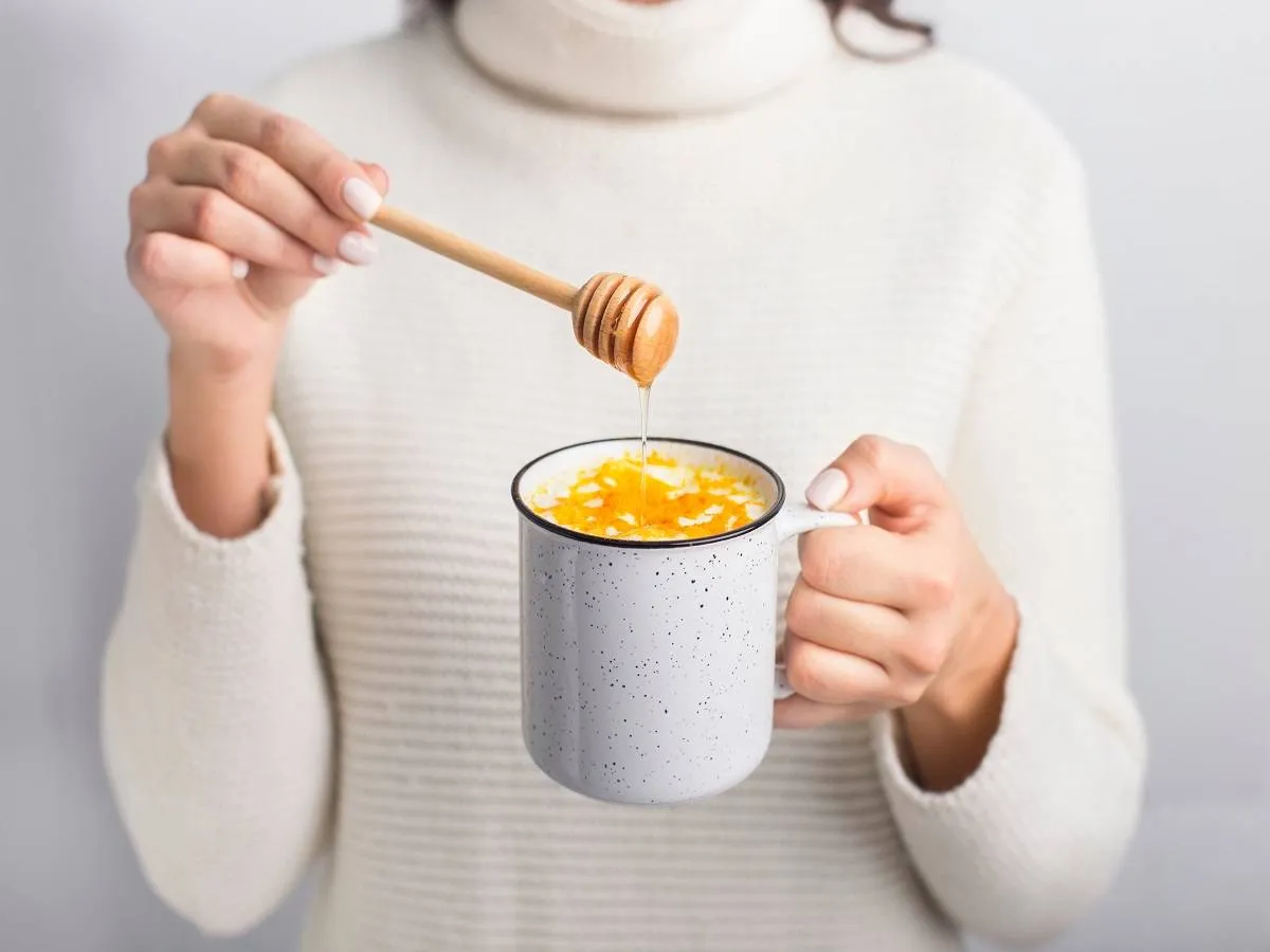 صورة لامرأة تمسك كوباً من العسل