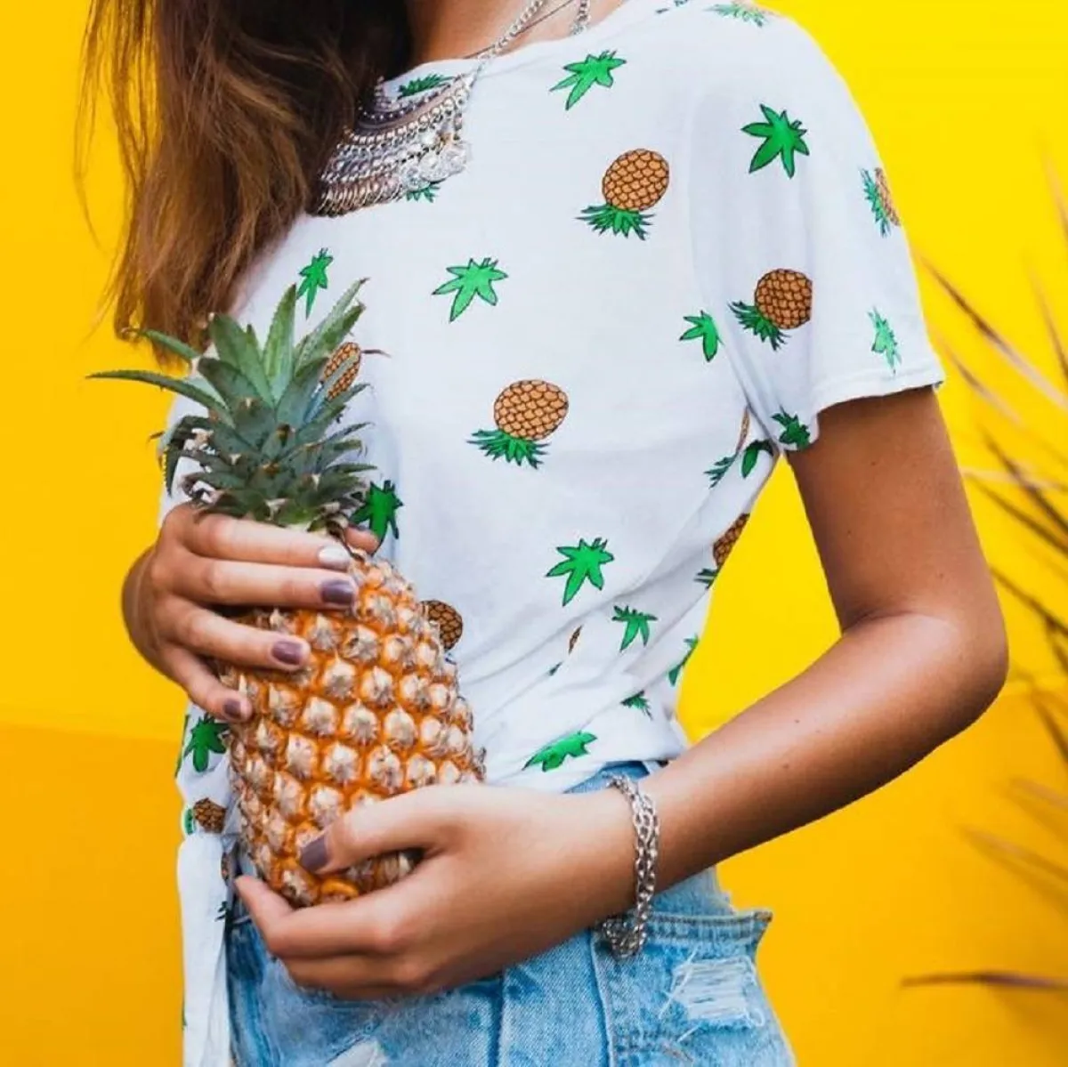 صورة لحامل تحمل ثمرة الأناناس