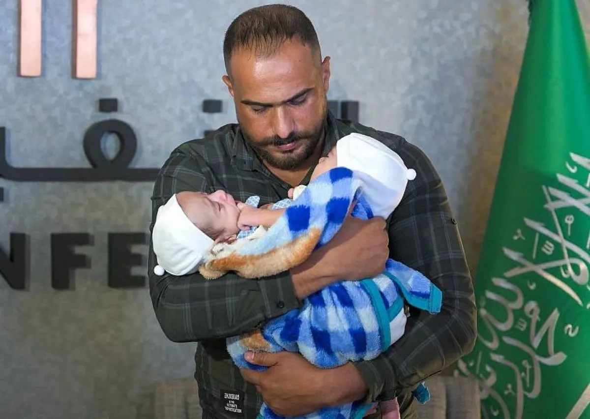 الأب العراقي مع طفليه. الصورة من "واس"