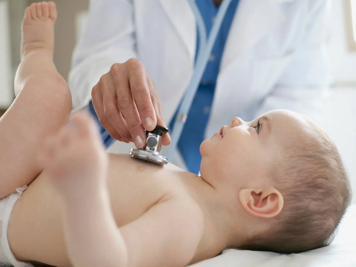 صورة لطبيب يفحص طفلاً رضيعاً
