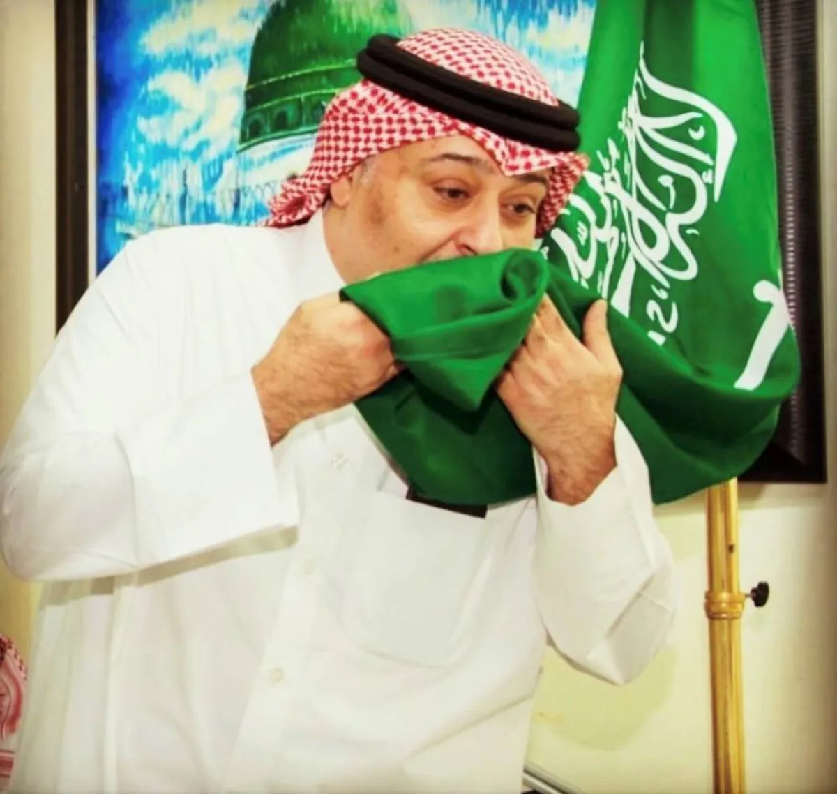 حسن البلام يقبل علم السعودية- الصورة من حسابه على الانستجرام