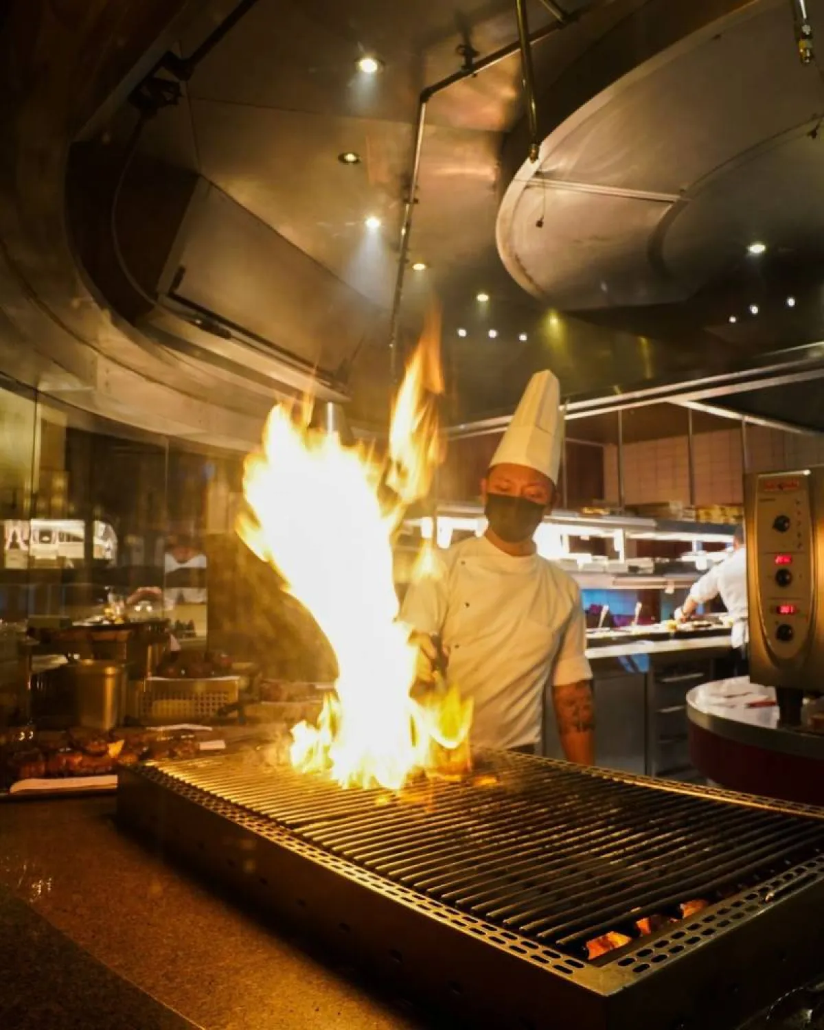 مشاهدة الشيف أثناء الطهي مستعرضاً مهاراته عبر مطبخ أشبه ما يكون مسرحاً مفتوحاً 