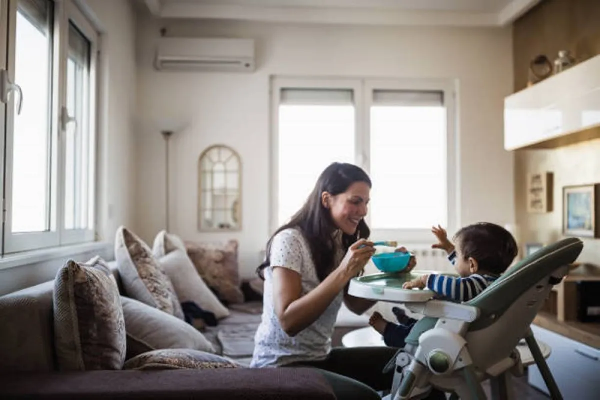 صورة لأم تقدم الطعام الصلب لطفلها