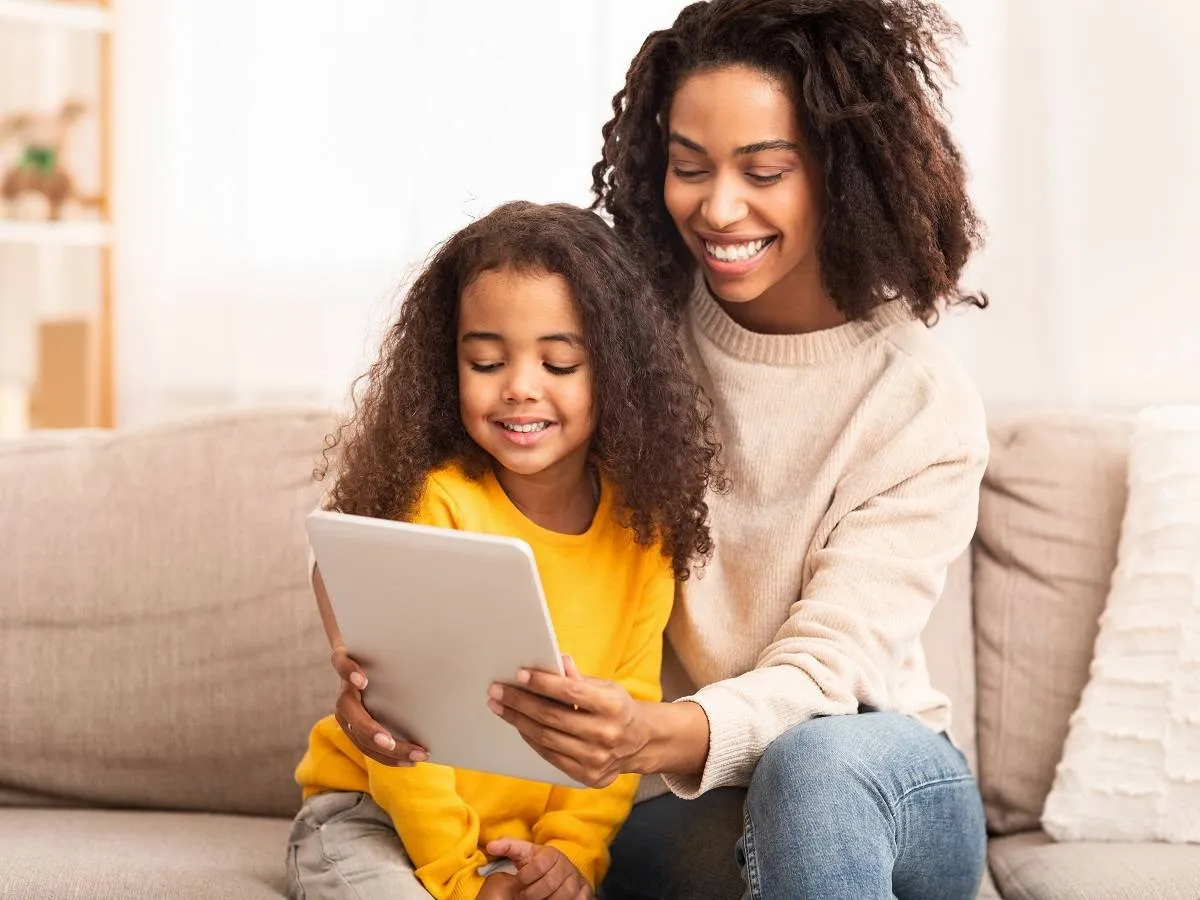 صورة لطفلة تنظرمع والدتها إلى شاشة التليفون