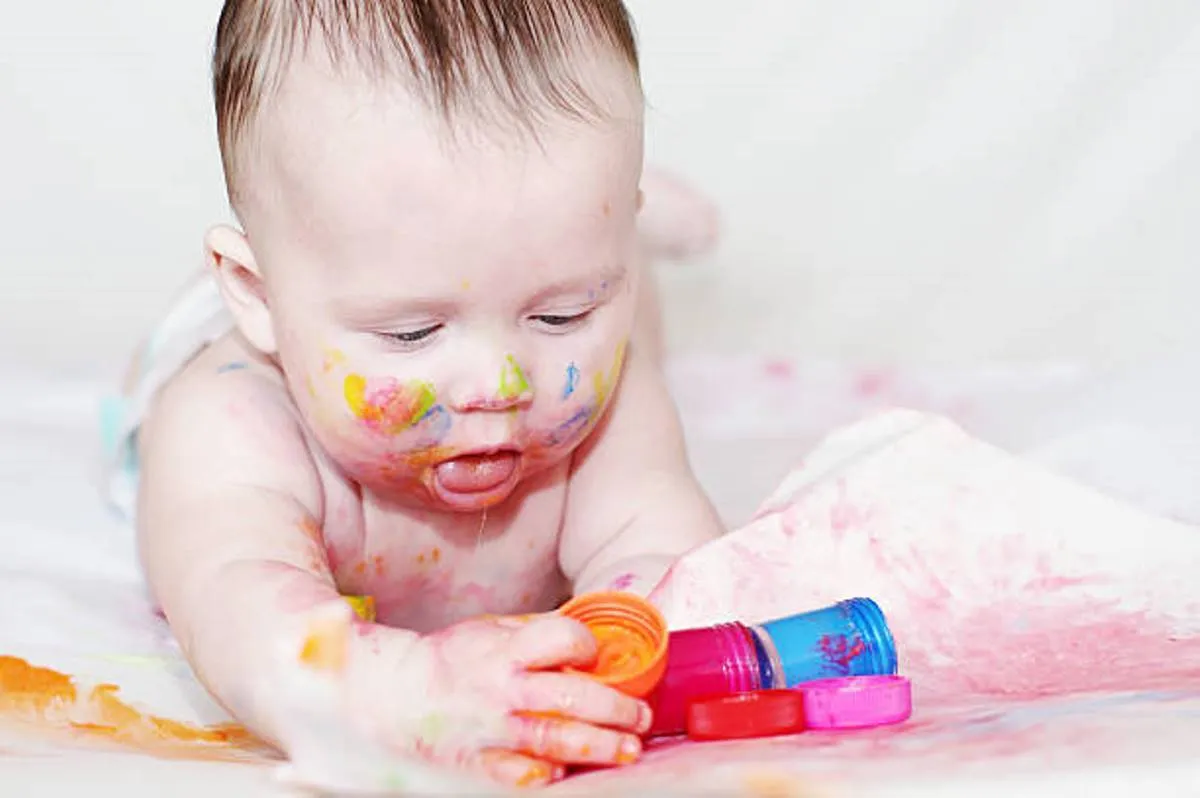 صورة لرضيع في عمر أربعة أشهر يمسك بيديه