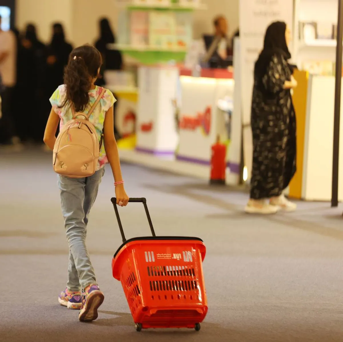 طفلة تتجول بين أروقة معرض الكتاب 