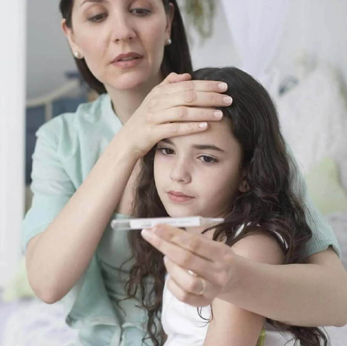 صورة لأم تتفحص ابنتهاالمريضة