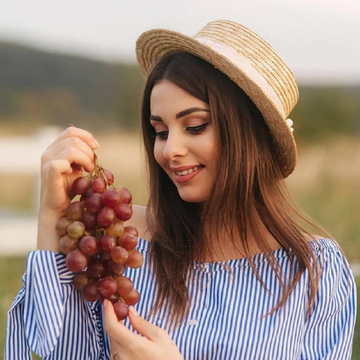 صورة لحامل تحمل عنقود العنب