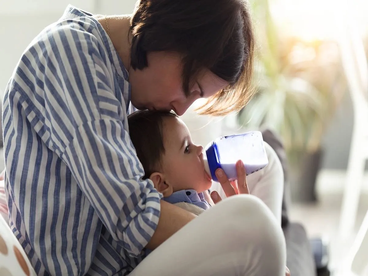 صورة لأم ترضع طفلها من الزجاجة