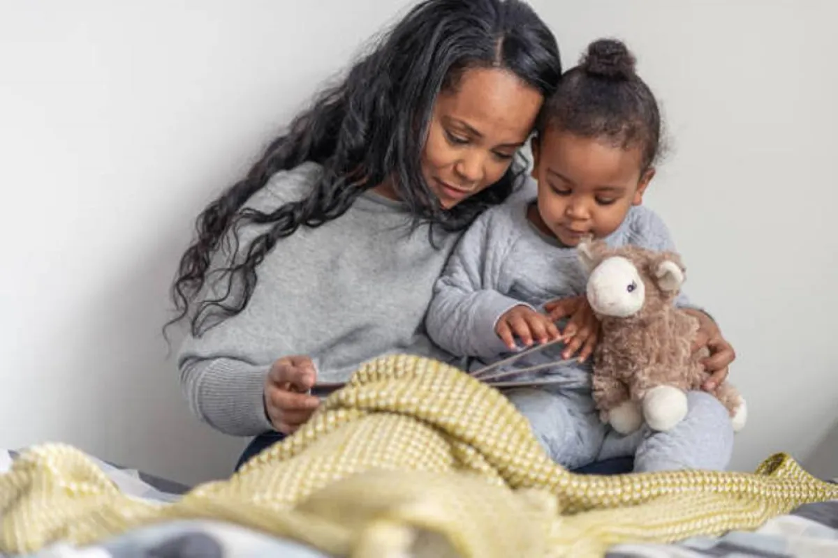 صورة لام تستمتع مع طفلتها بقراءة قصة قبل النوم