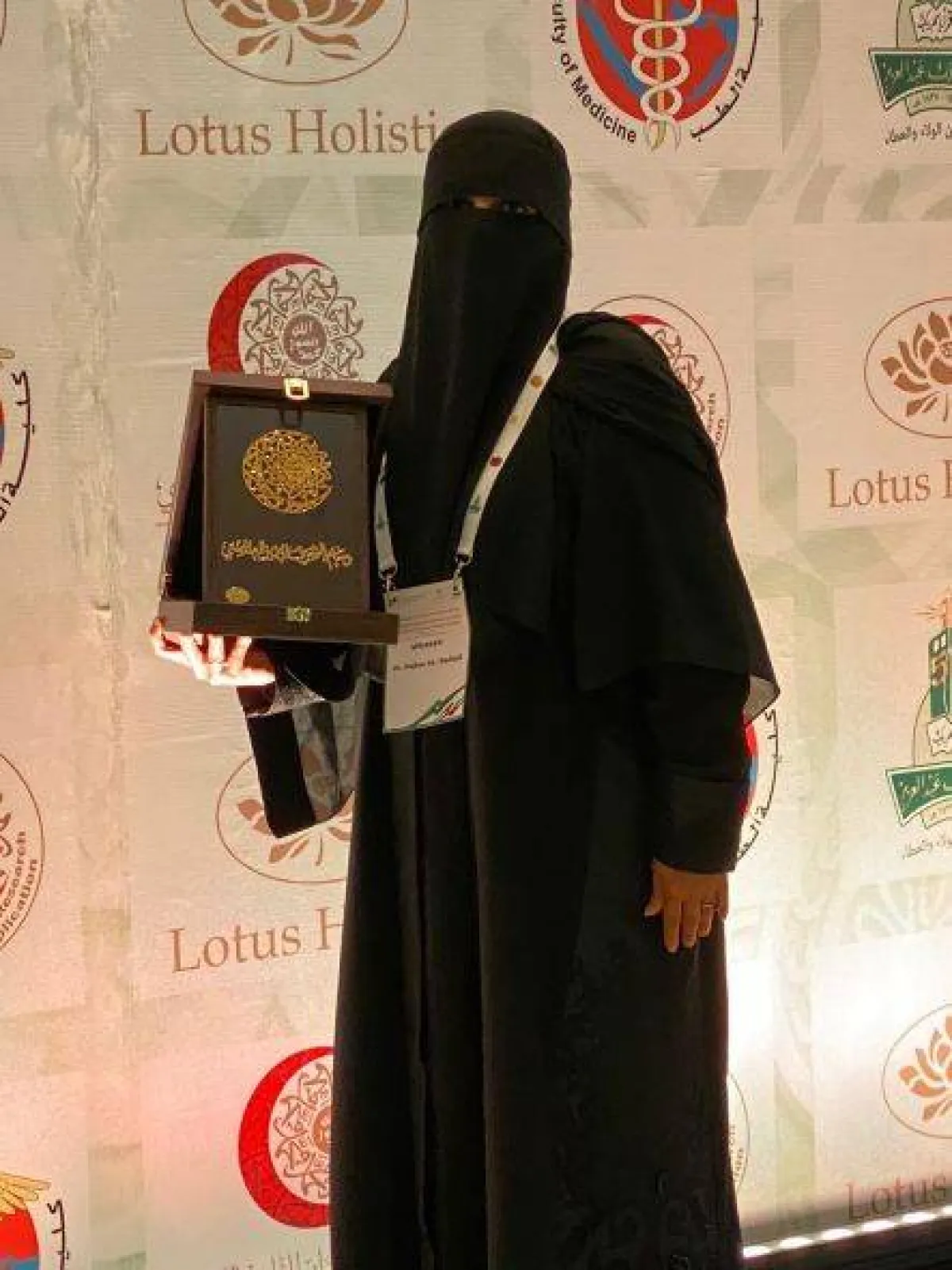 الدكتورة نجلاء الردادي وهي تتسلم أحد الأوسمة