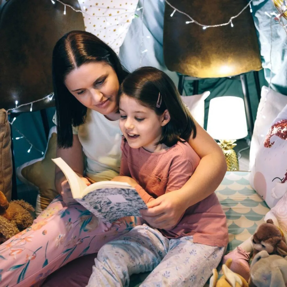 صورة طفلة مستمتعة بالقراءة مع أمها