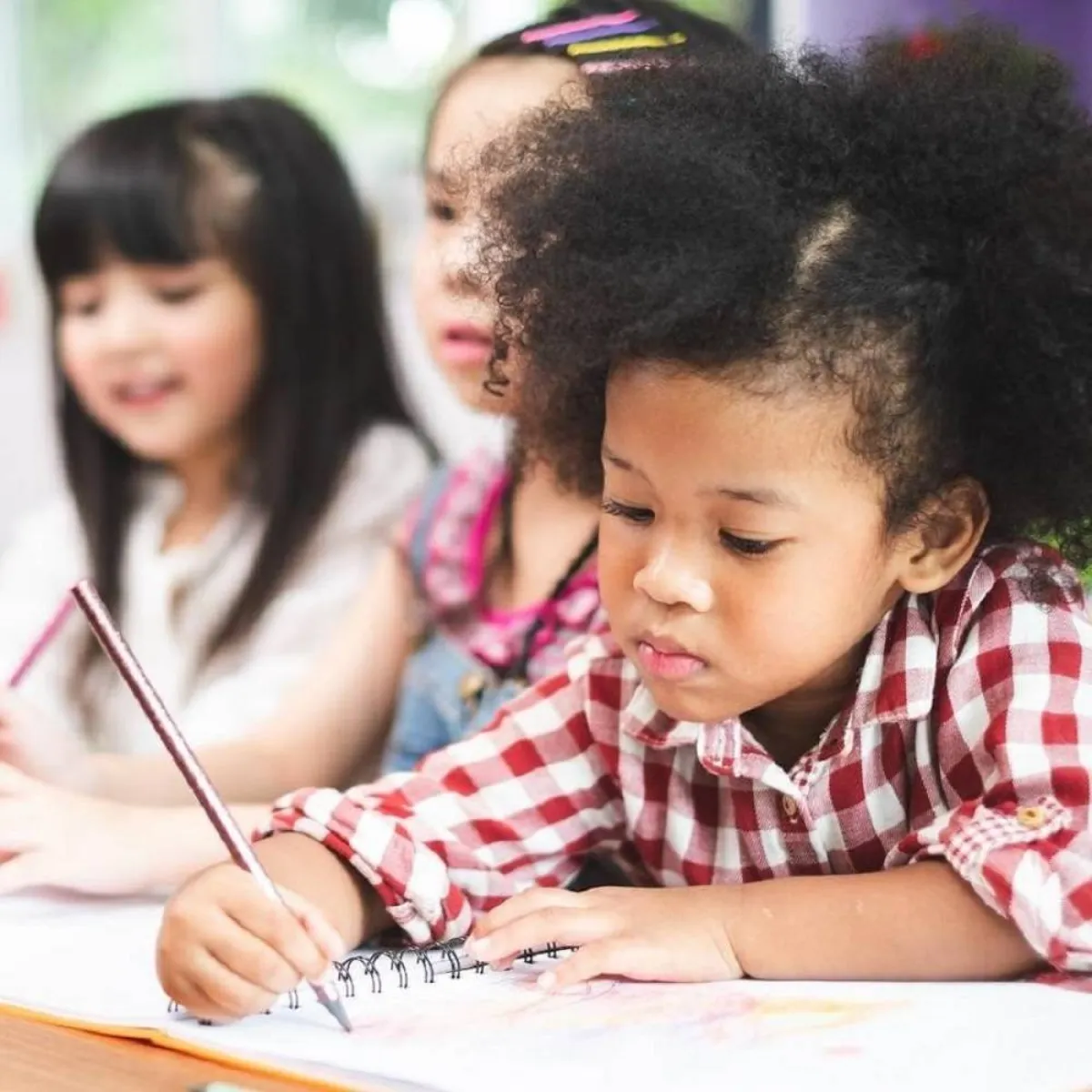 صورة لطفلة ترسم وسْط صديقاتها