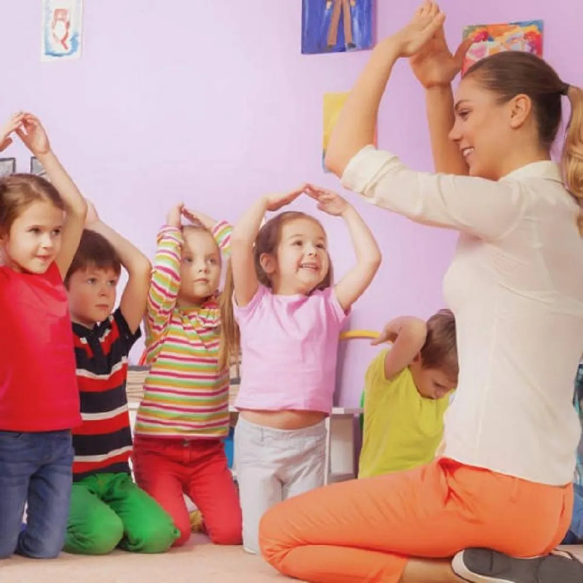 صورة للعب جماعي للأطفال مع معلمتهم