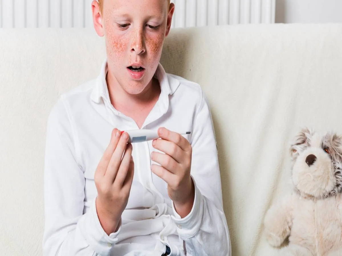 صورة لطفل يحمل مقياس الحرارة