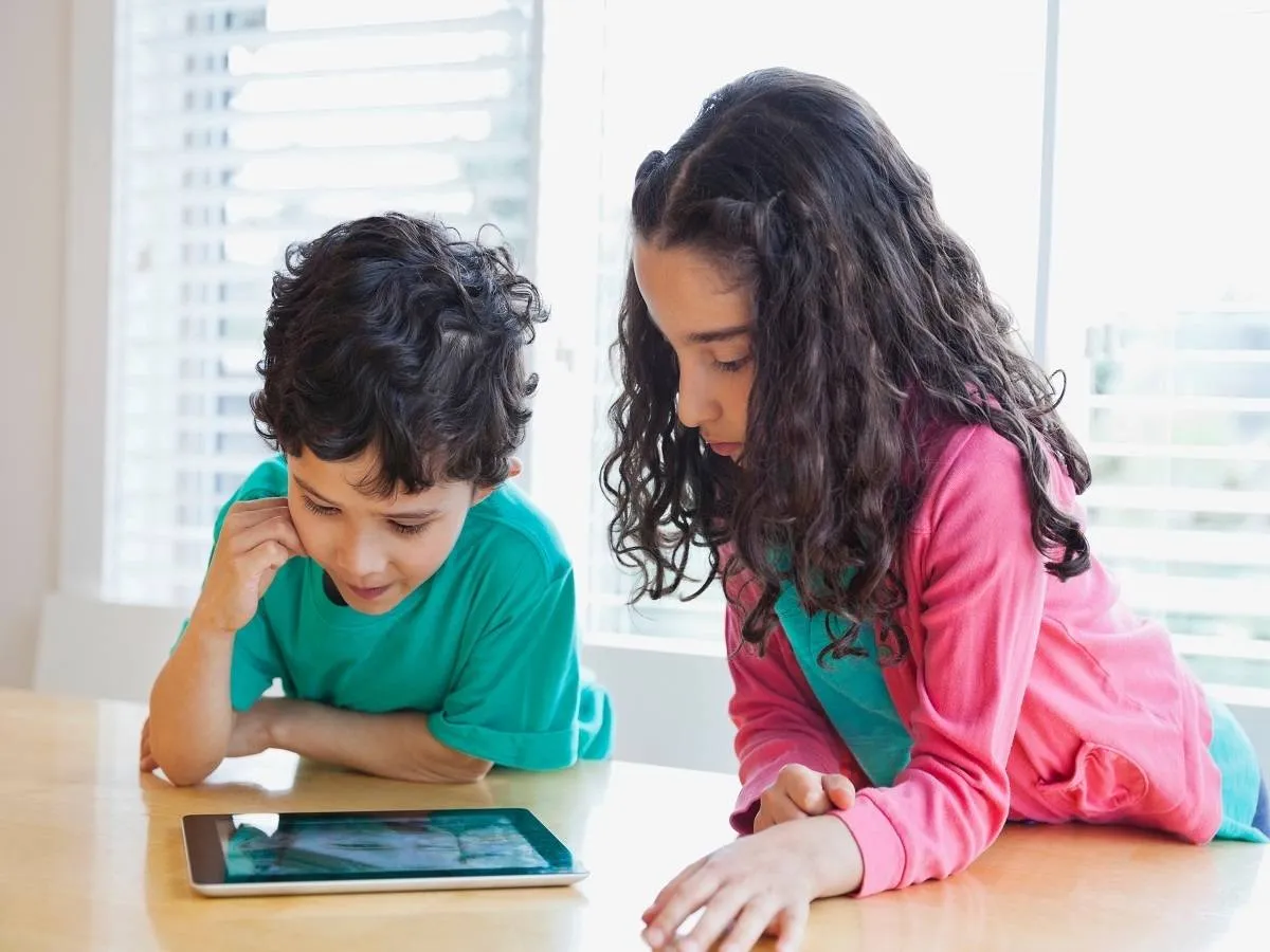 صورة لأطفال يشاهدون شاشة الهاتف