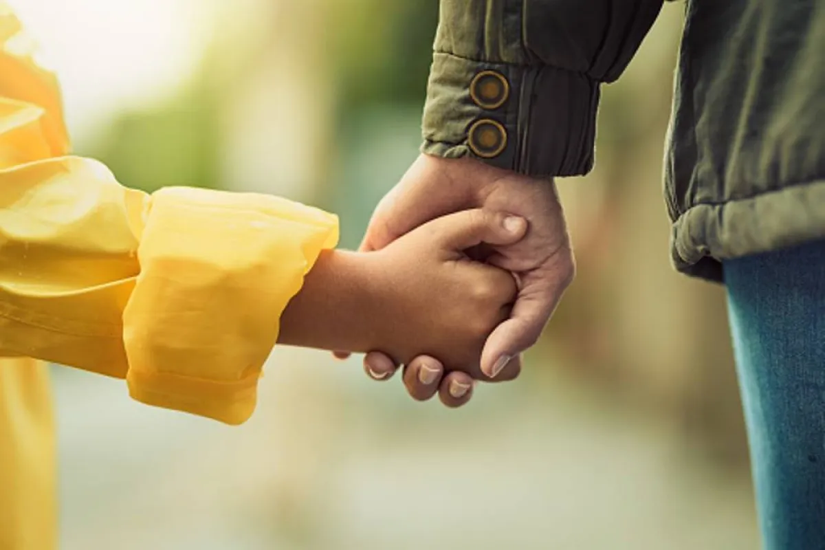 صورة لأم تمسك بيد طفلها