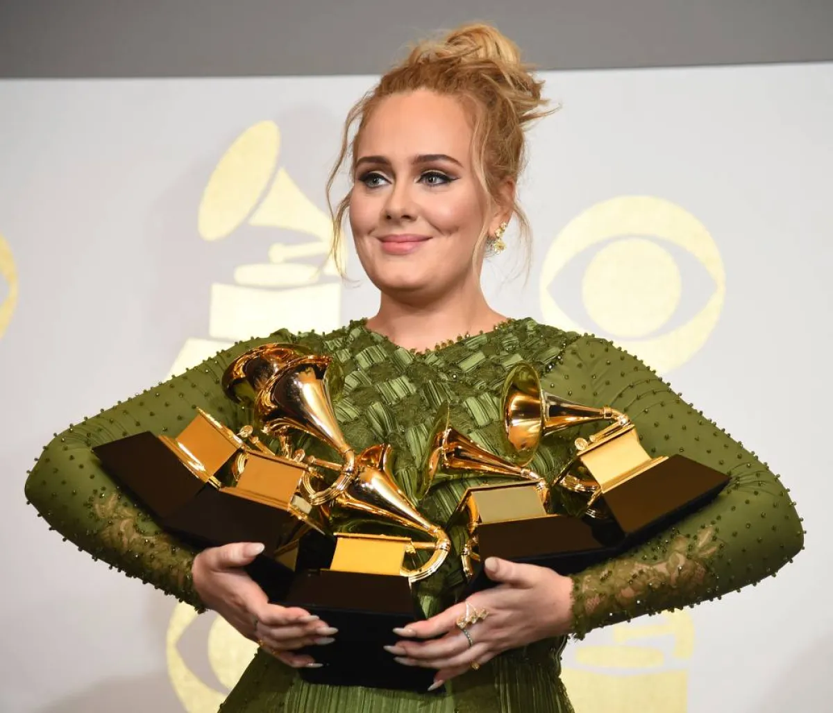 Adele poses in the press room with her trophies, including the top two Grammys of Album and Record of the Year for her blockbuster hit "Hello" and the album "25", during the 59th Annual Grammy music Awards on February 12, 2017, in Los Angeles, California. Robyn BECK / AFP