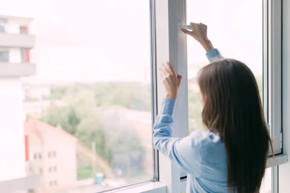 صورة لامرأة تفتح النافذة