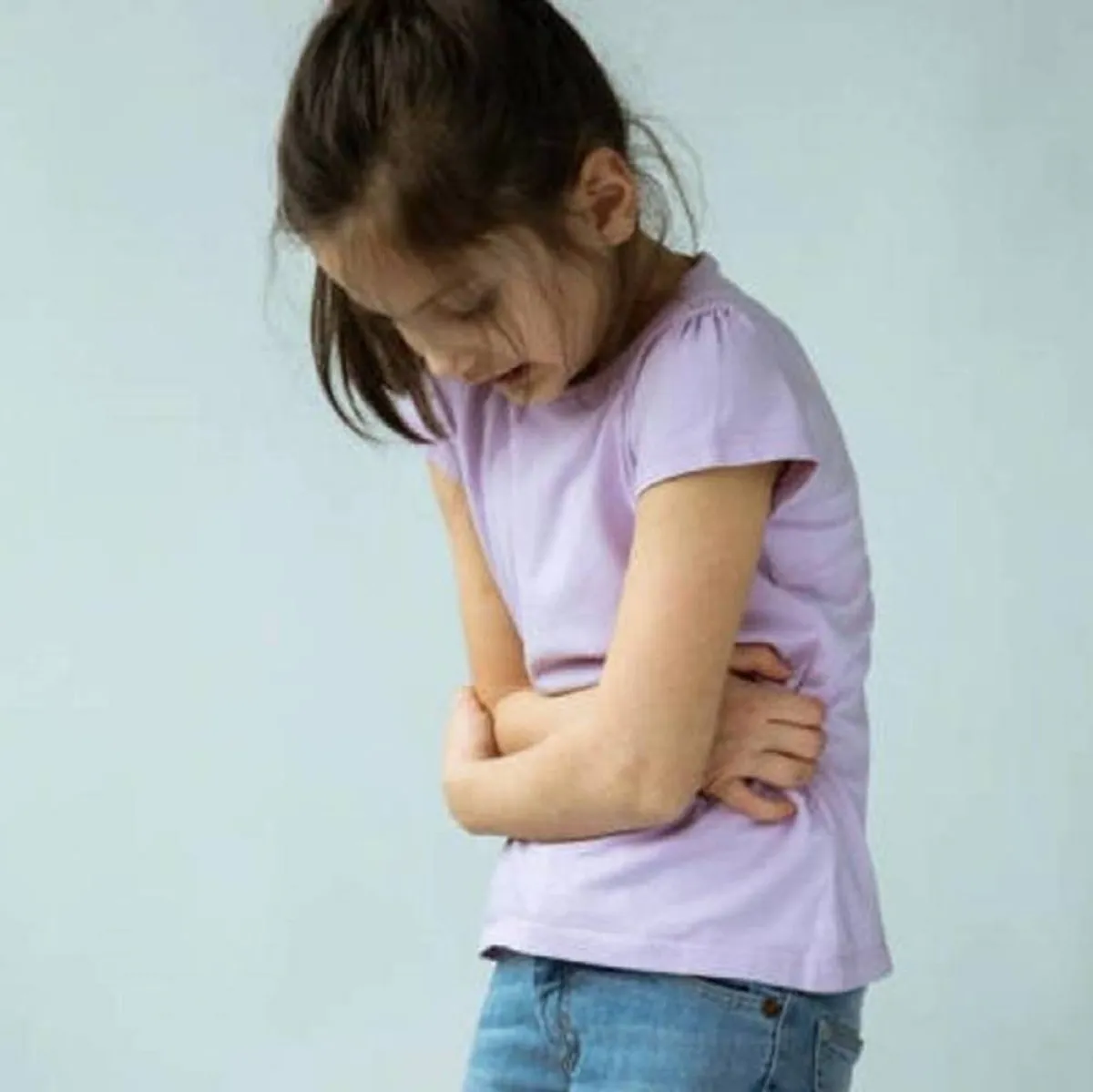 صورة لطفلة تمسك ببطنها