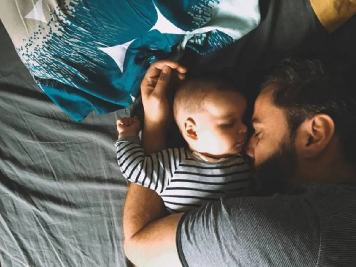 صورة لرضيع ينام في سرير الكبار