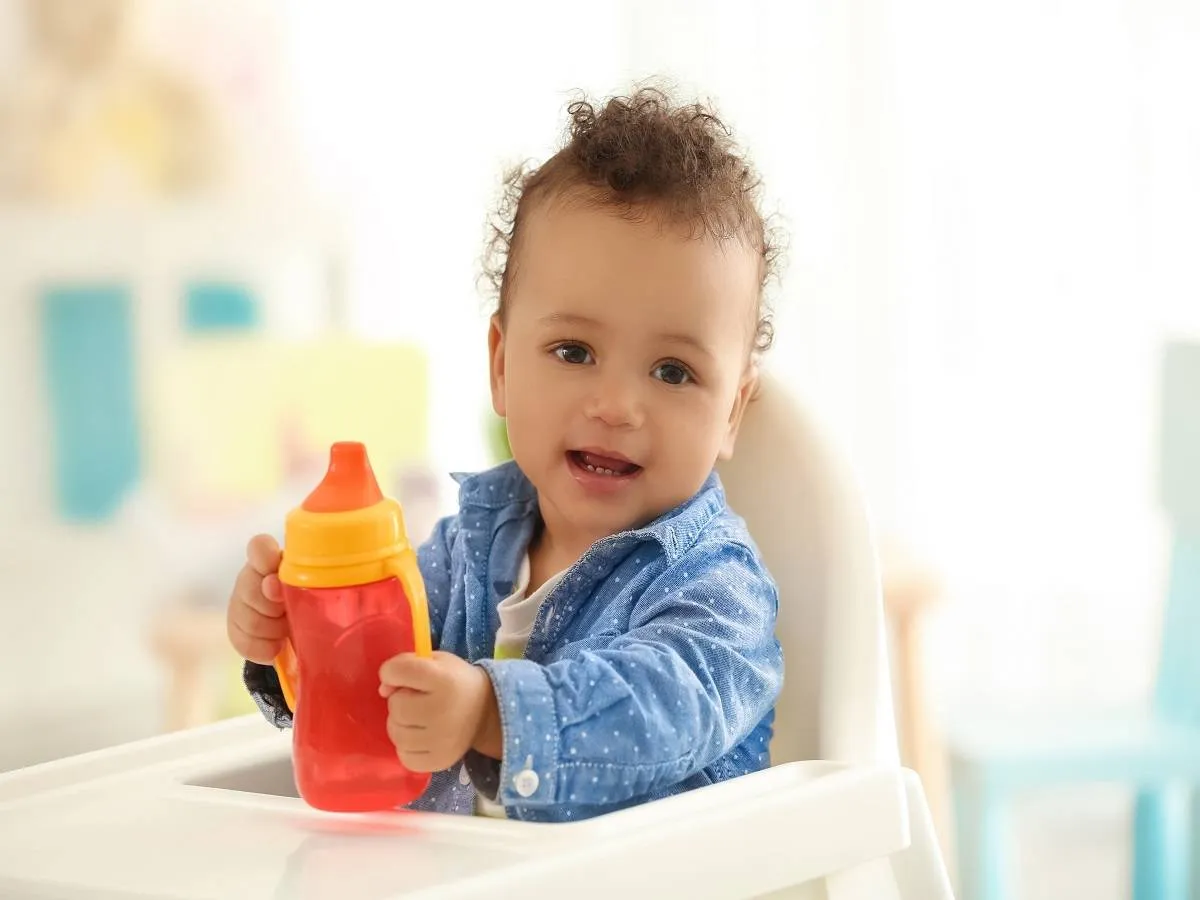 صورة لطفل رضيع يحمل كوباً