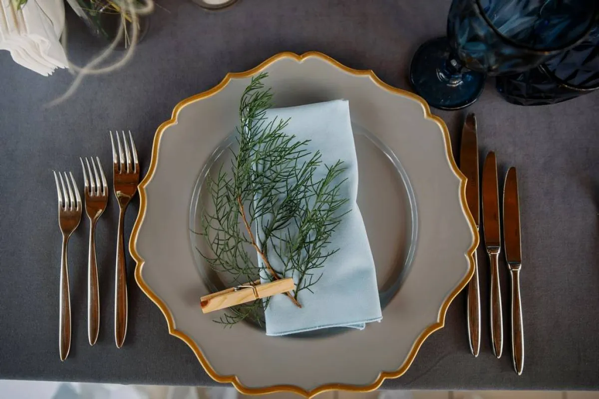 أدوات المائدة تُنسّق بصورة قريبة من ديكور حفل الزفاف