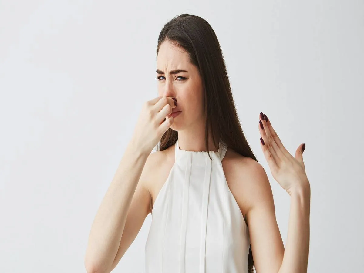 صورة لامرأة تغطي أنفها