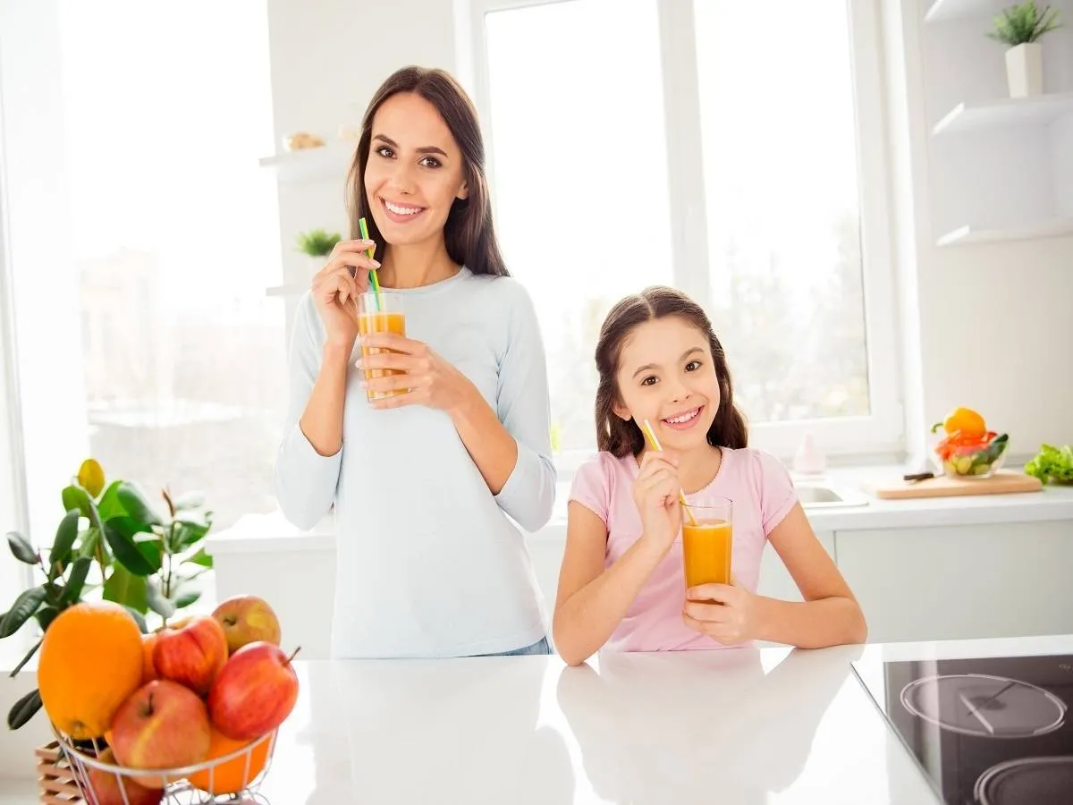 صورة لأم وابنتها تتناولان عصير البرتقال
