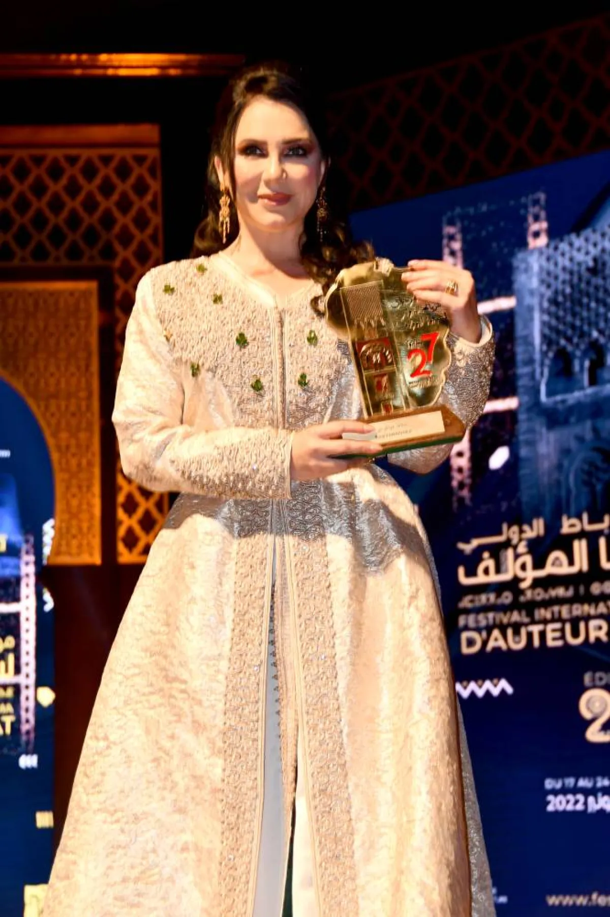 سلاف فوخراجي بالقفطان وتحمل درع التكريم