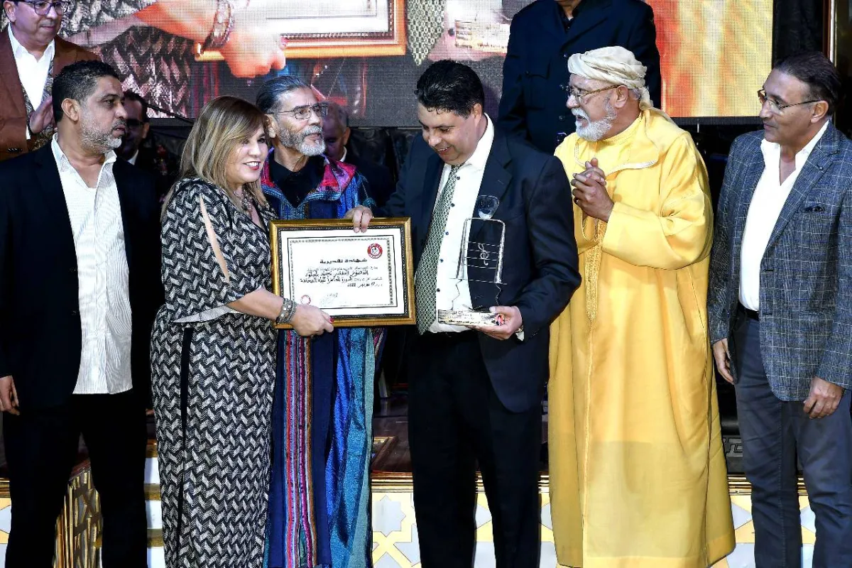 الممثلة أمال الثمار تقدم شهادة تقديرية للزميل والمصور الصحفي  محمد بلميلود