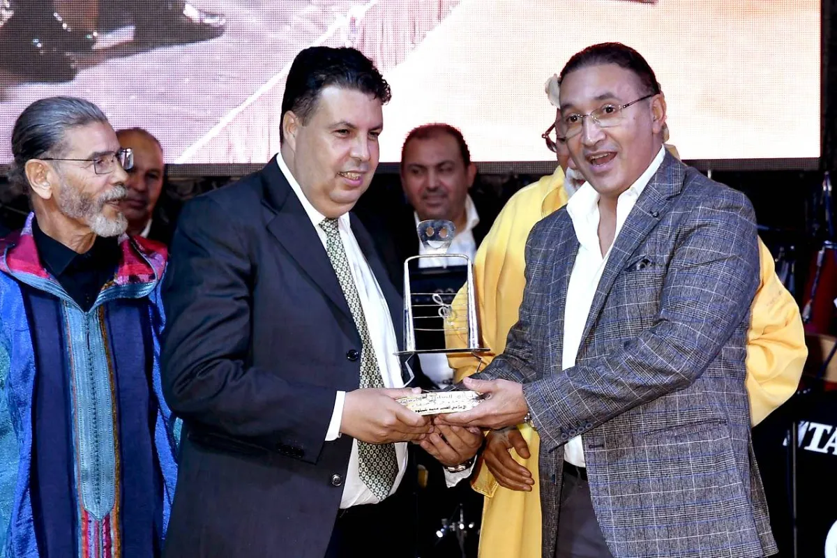 الإعلامي محمد عمورة يقدم درع التكريم للزميل والمصور الصحفي محمد بلميلود