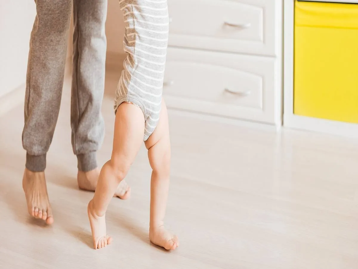 صورة لطفل يحاول المشي بمساعدة والدته