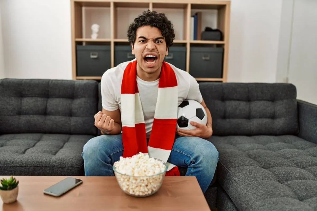 مشجّع يشاهد مباراة كروية