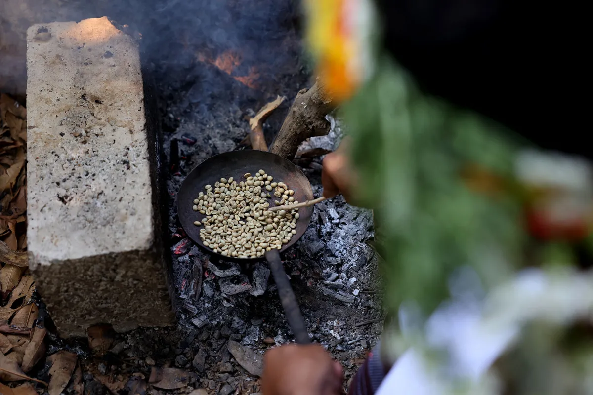 Saudi farmer Ahmed al-Malki, 42, roasts Khawlani coffee beans at a coffee farm in Saudi Arabia's southwestern region of Jizan on January 26, 2022. Jizan is known for its red Khawlani coffee beans, often blended with cardamom and saffron to give a yellowish hue of coffee -- locally known as ghawa. It remains an integral part of Saudi culture, so much so that the government has designated 2022 as "The Year of Saudi Coffee".  Fayez Nureldine / AFP
