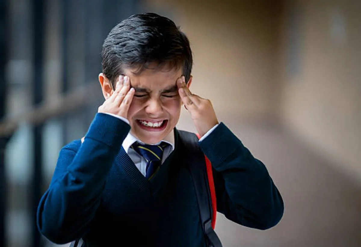 صورة لطفل يعاني من الصداع وهو في المدرسة