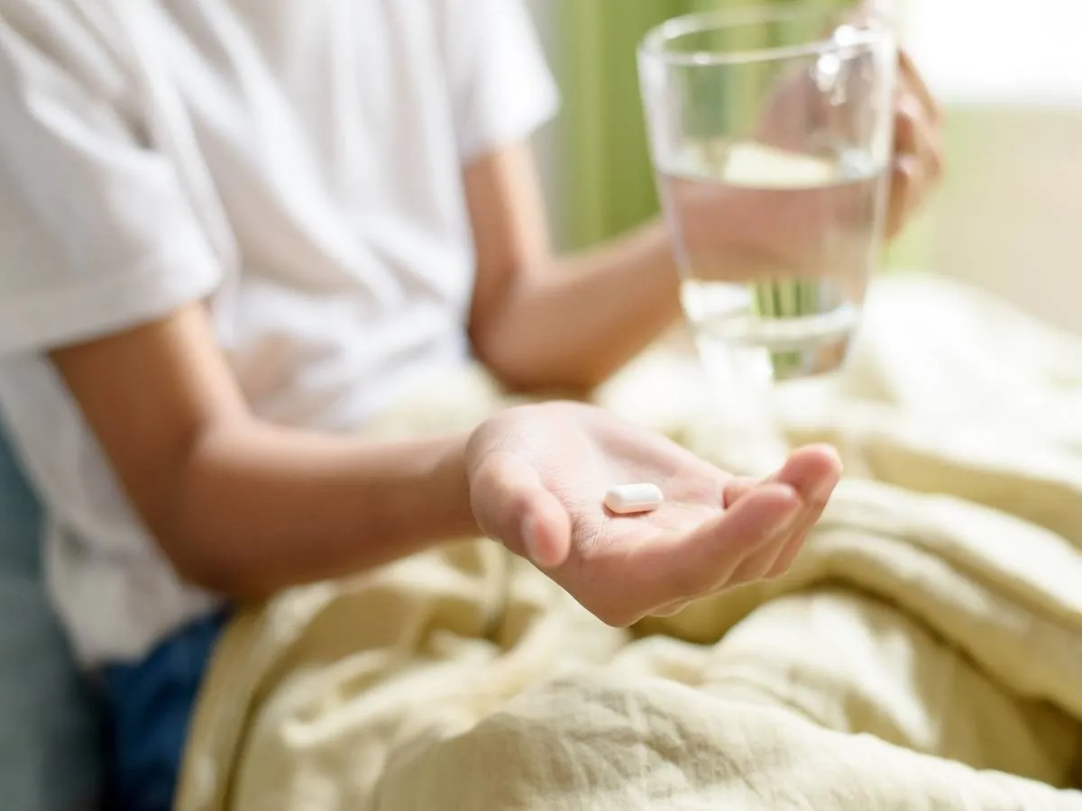 صورة لطفل يحمل دواء وكوب ماء