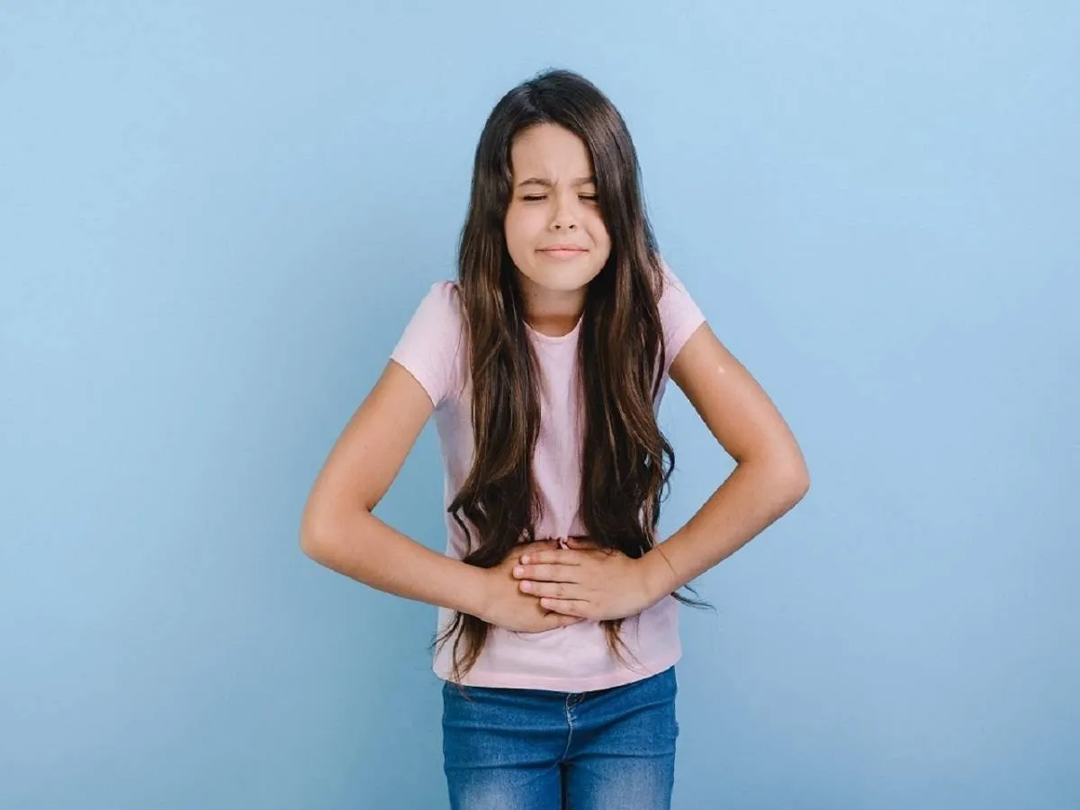 صورة لفتاة تعاني من آلام بالمعدة