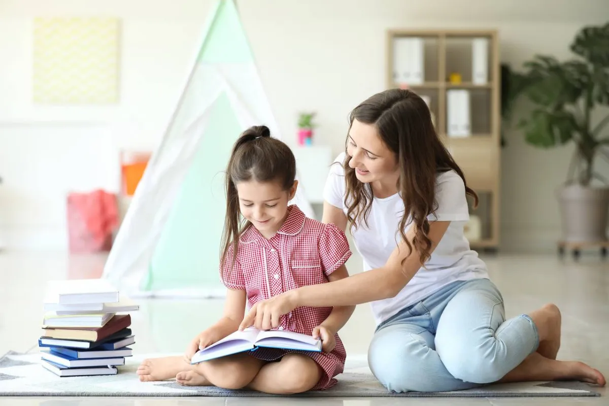 صورة الأم تقرأ لطفلتها