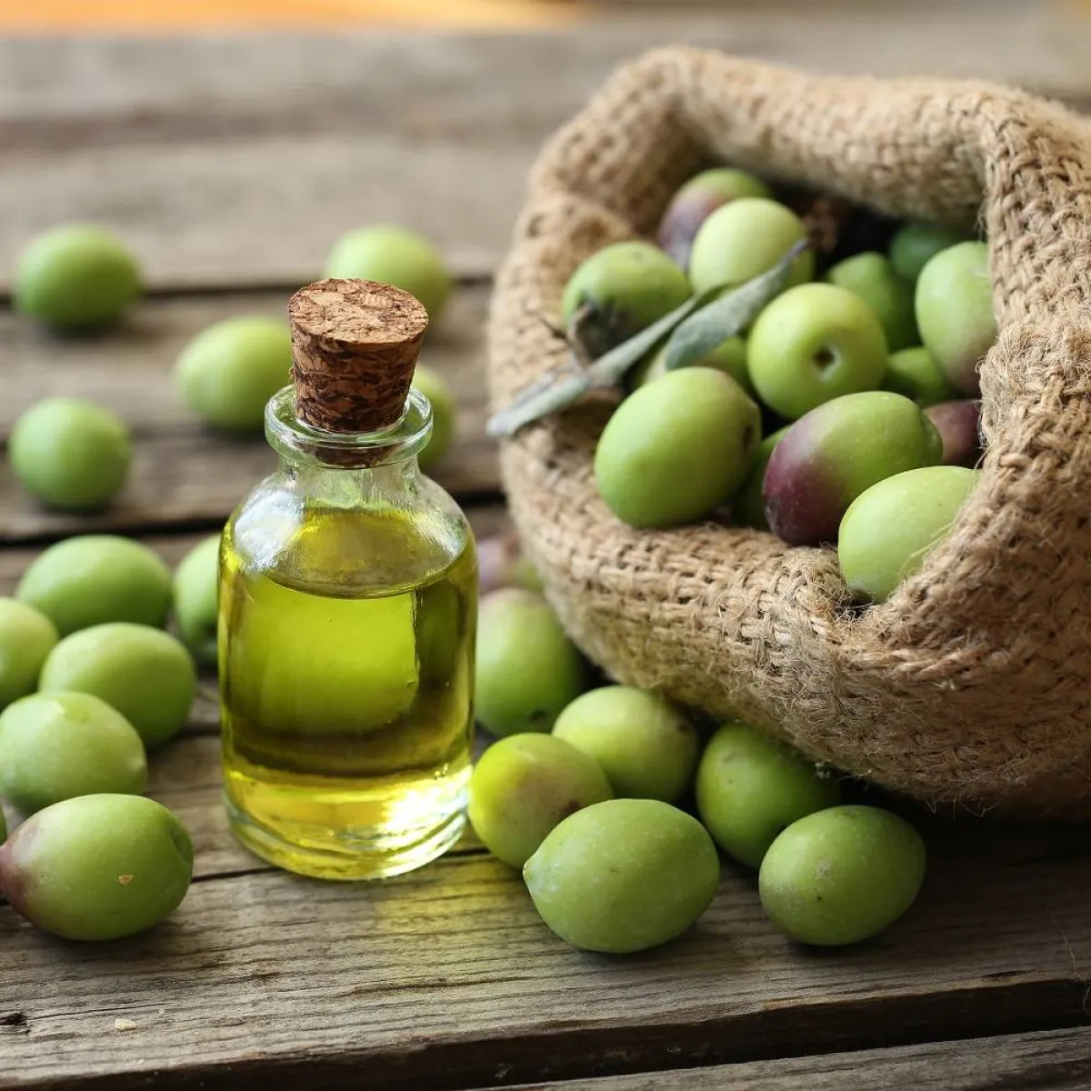 صورة لحبات الزيتون وزجاجة لزيت الزيتون