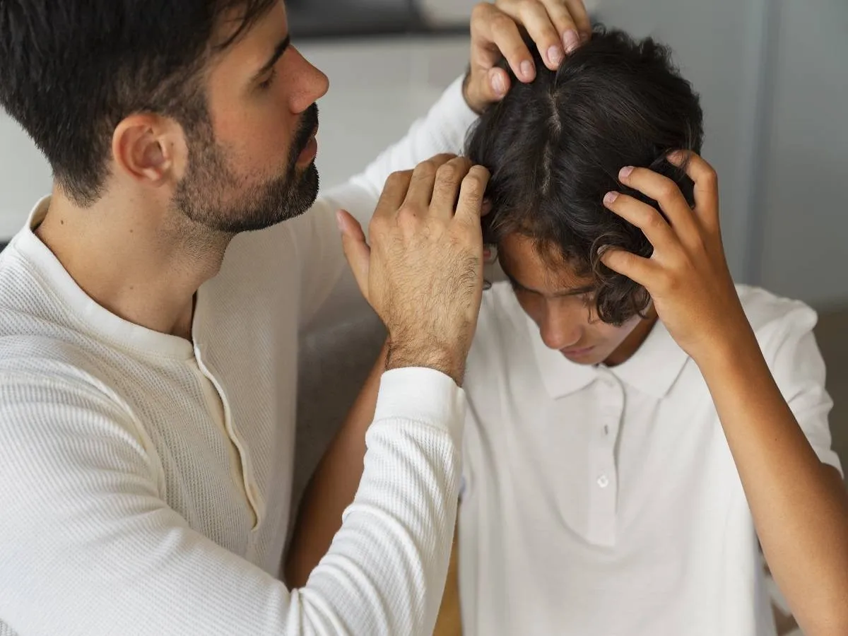 صورة لأب يفحص رأس طفل