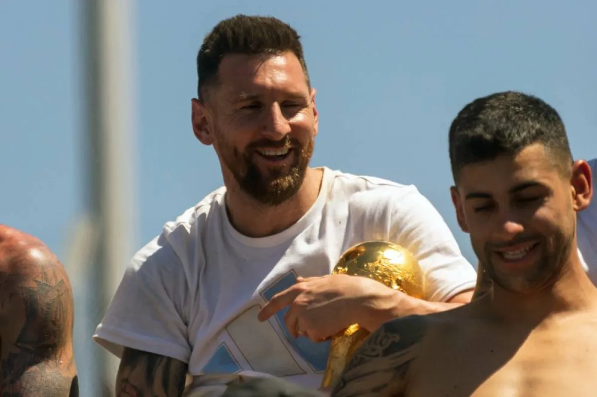 Argentina's Lionel Messi (L) holds the FIFA World Cup Trophy in Buenos Aires province, Argentina on December 20, 2022. TOMAS CUESTA / AFP