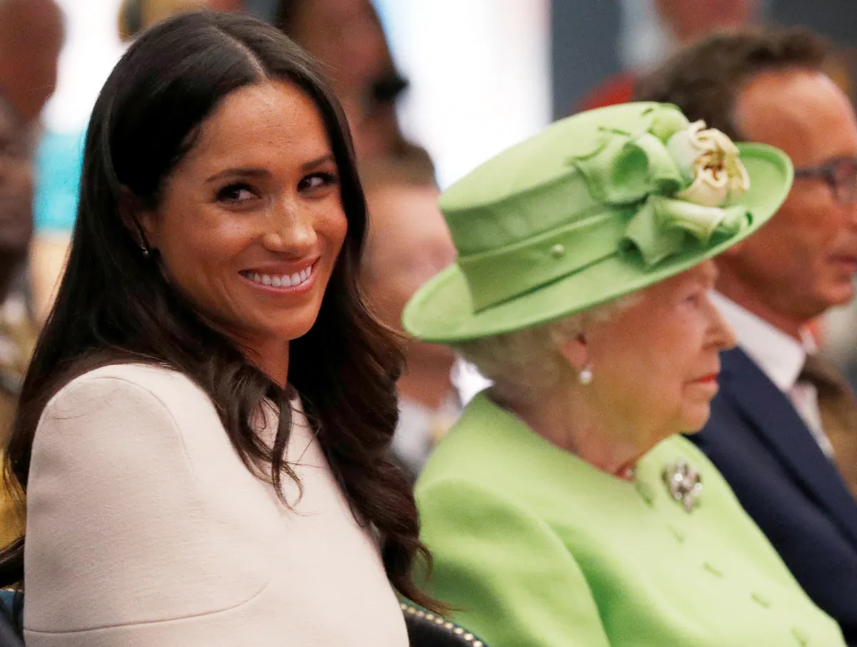 Britain's Queen Elizabeth II and Meghan, Duchess of Sussex gesture during their visit to the Storyhouse in Chester, Cheshire on June 14, 2018. PHIL NOBLE / POOL / AFP